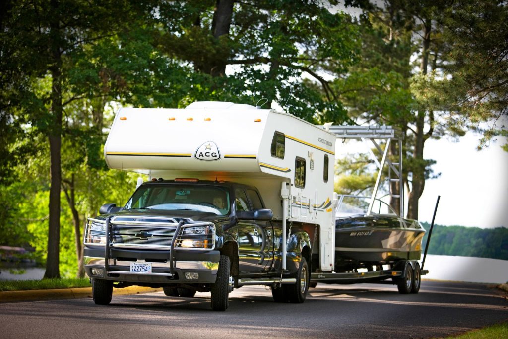 Chevy truck hauling truck camper and boat